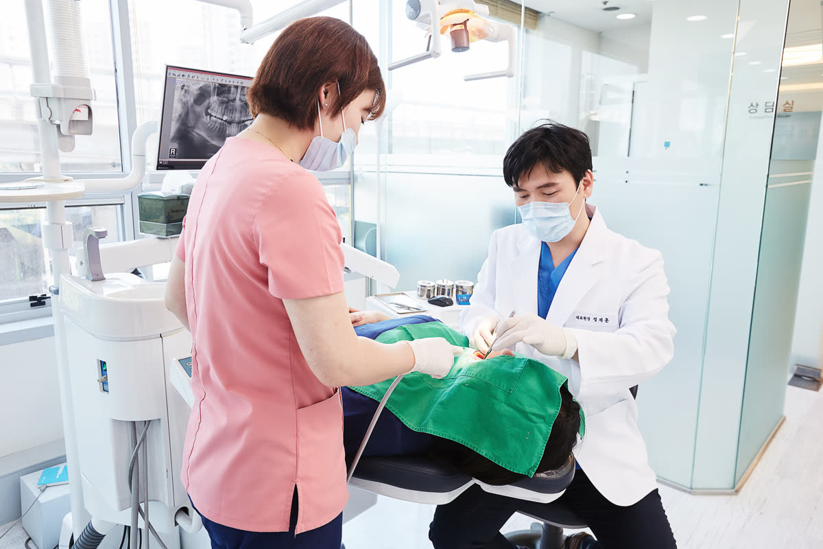 치과위생사와 함께 환자를 진료하는 석계탑치과 정재훈 대표원장